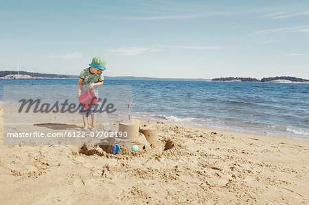 Child making moat around sandcastle