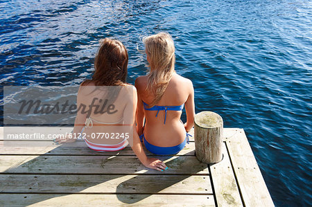 Teenage girls relaxing on wooden pier
