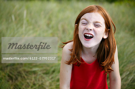 Girl grimacing in tall grass