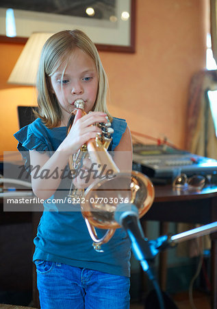 Girl playing trumpet into microphone