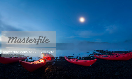 Man using light to examine canoes