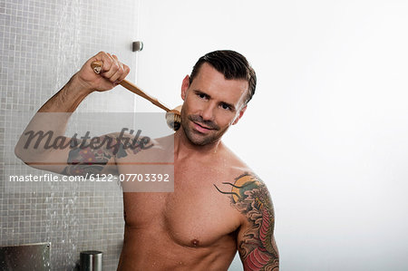 Man scrubbing his back in shower