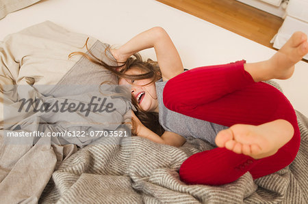 Smiling girl playing in bed