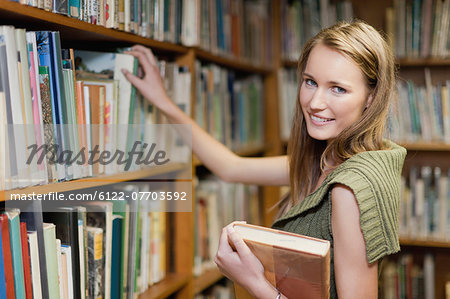 Student selecting books in library