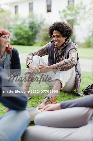 Students talking on grass on campus