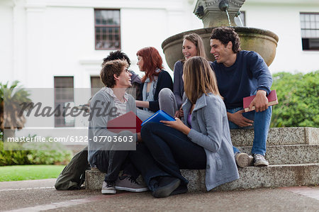 Students talking on fountain on campus