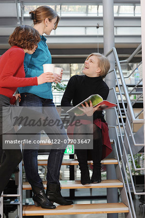 Businesswomen talking on steps in office