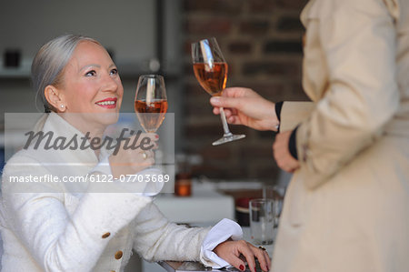 Older women toasting each other in cafe