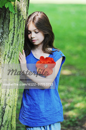 Girl leaning against tree in park