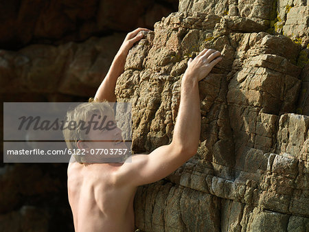 Rock climber scaling steep rock face