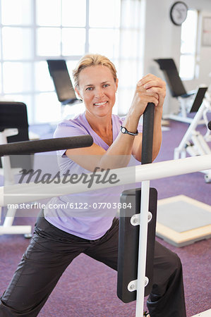 Woman using weights machine in gym