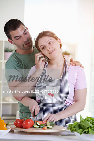 Man holding phone for cooking girlfriend