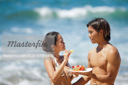 Couple eating together on beach