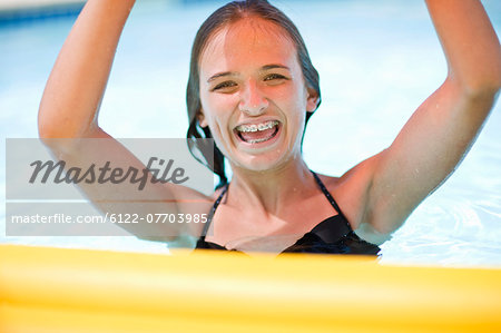 Teenage girl in braces playing in pool