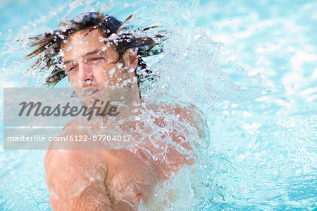 Man splashing in pool