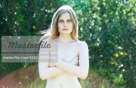 Nude teenage girl standing outdoors
