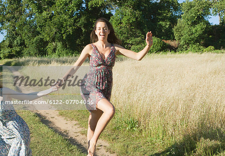 Teenage girls skipping on dirt path