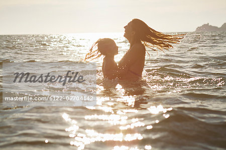 Mother and daughter playing in ocean