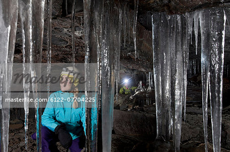 Hiker admiring icicles in cave