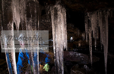 Hiker with icicles in glacial cave