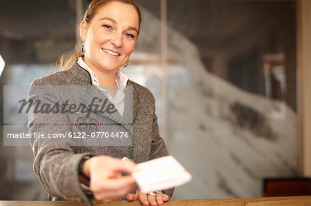 Hotel concierge with card at desk
