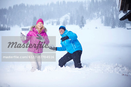 Couple having snowball fight outdoors