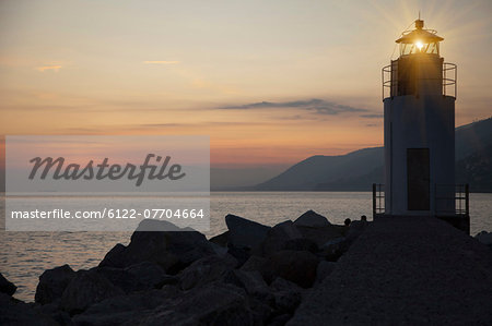Lighthouse shining over rocky beach