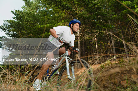 Man mountain biking on dirt path