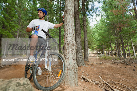 Mountain biker drinking water in forest