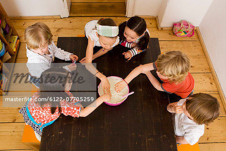 Children sharing food in kitchen