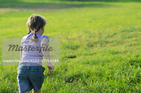 Girl running in rural meadow