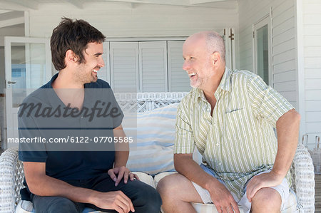 Father and son talking on sofa