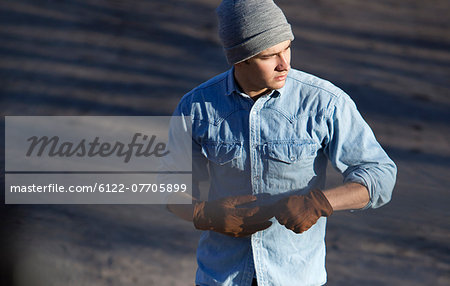 Man pulling off gloves outdoors