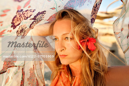 Woman playing with fabric on beach