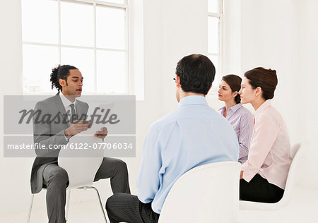 Businessman reading to colleagues