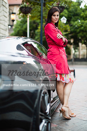 Smiling woman leaning on sports car