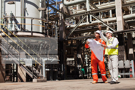 Workers talking at oil refinery Workers talking at oil refinery