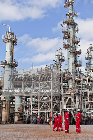 Workers talking at oil refinery