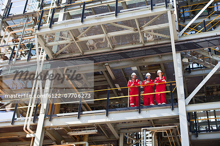 Workers standing on ledge together Workers standing on ledge together