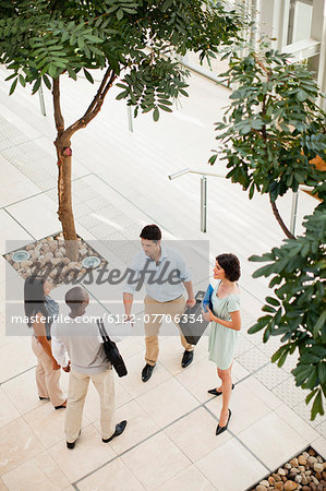 Business people shaking hands in lobby