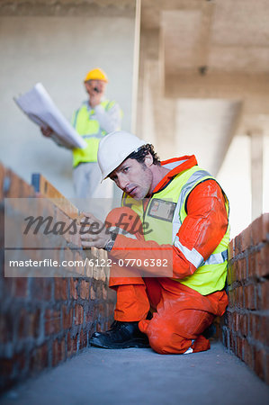 Worker laying brick at construction site
