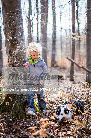 Boy and dog exploring in forest