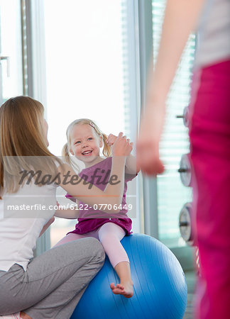 Trainer working with girl in gym