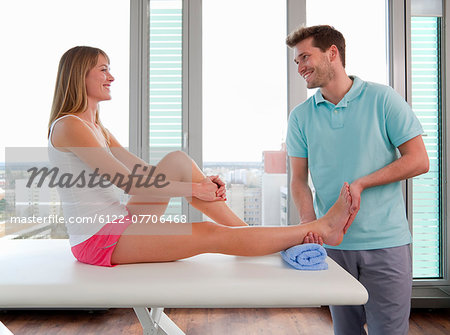 Doctor examining womans feet in office