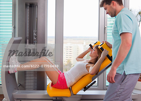 Trainer working with woman in gym
