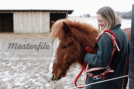 Woman smiling with horse in yard