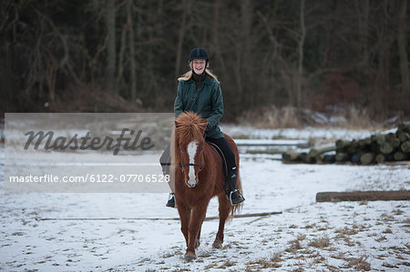 Woman riding horse in snow