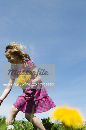Girl picking wildflowers in field