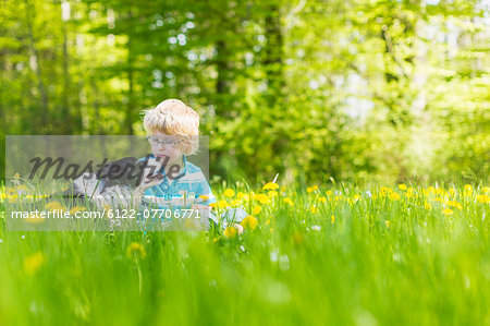 Boy with dog in field of tall grass