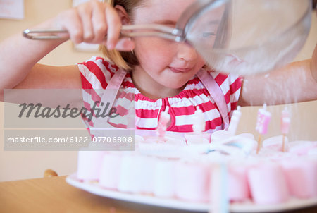 Girl dusting candies with sugar